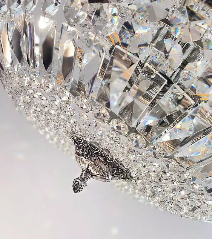Close-up of an ornate Kristall Korblüster SCHÖNBRUNN chandelier in antique silver with cut crystals, showcasing intricate detailing.