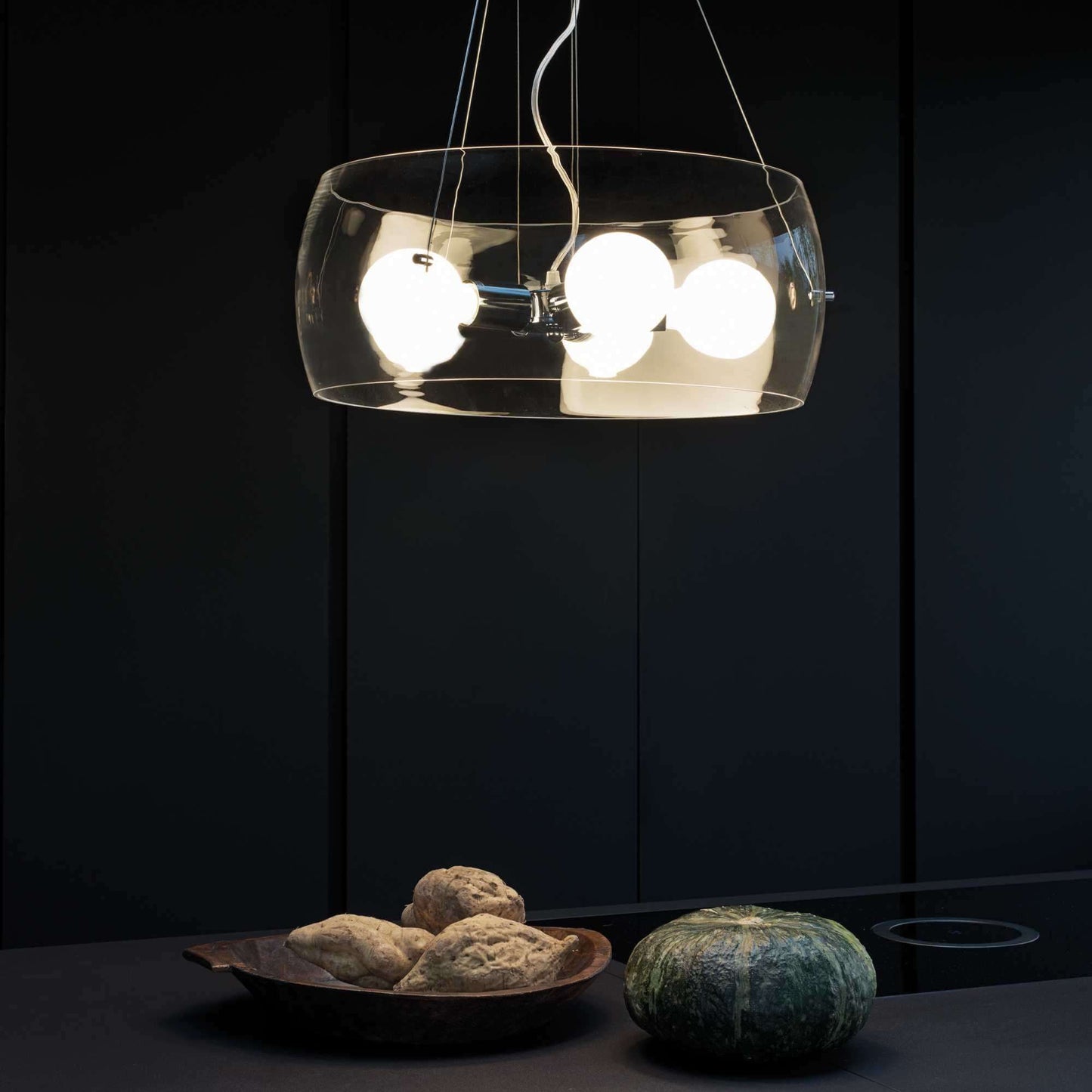 Ideal Lux AUDI-10 pendant light with transparent glass in modern kitchen setting, featuring dimmable lighting and chrome metal frame.