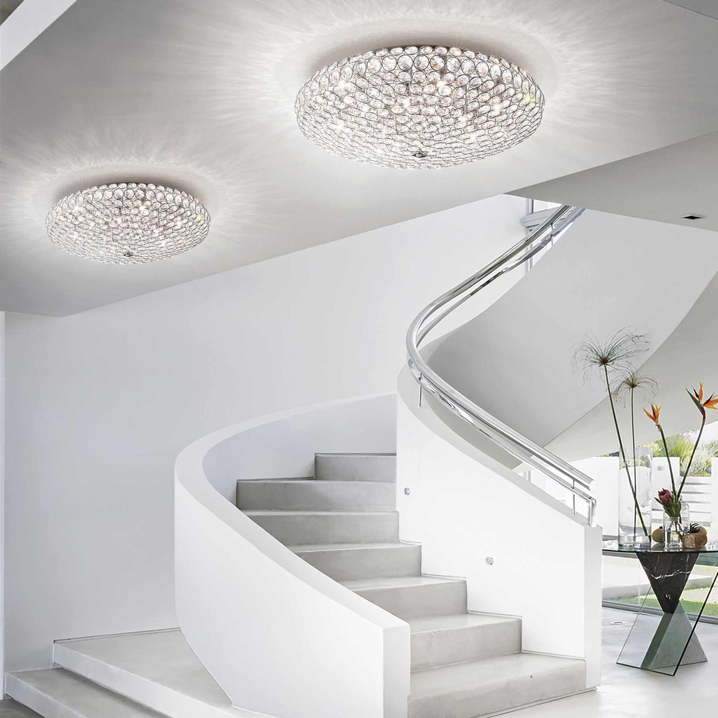 Modern staircase with IDEAL Lux King 9-light gold ceiling fixture featuring sparkling crystals, enhancing elegance in a contemporary space.