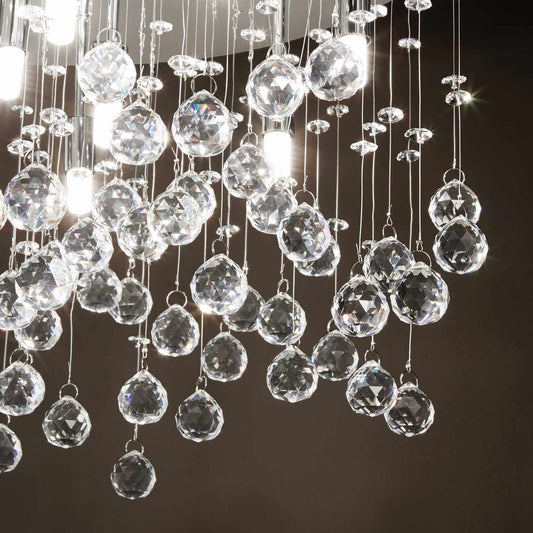 Close-up of Ideallux MOONLIGHT chandelier with crystal and gold accents, featuring dimmable 8 lights and sparkling crystal droplets.