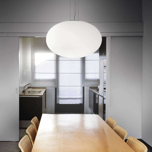 Ideallux Pendelleuchte CANDY 50cm in modern dining room, adjustable height with white glass diffuser, over wooden table.