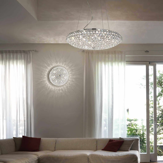 Elegantly lit room featuring the Ideal Lux King Ø65cm pendant light with sparkling crystals and adjustable height.