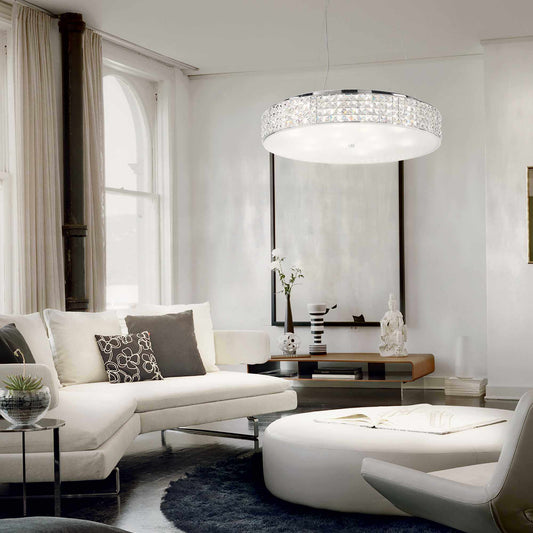 Modern living room with Ideal Lux Kristall Pendelleuchte ROMA Ø60cm, featuring chrome and satin glass, casting elegant lighting.
