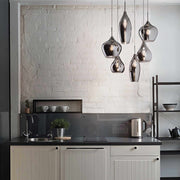 Modern kitchen with Ideal Lux SOFT pendant light in blown smoked glass, featuring unique shapes and chromed metal accents.