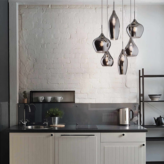 Modern kitchen with Ideal Lux SOFT pendant light in blown smoked glass, featuring unique shapes and chromed metal accents.