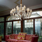 Elegant Strauss chandelier with 18 hand-blown glass lights, chrome and crystal arms, illuminating a luxurious living room.