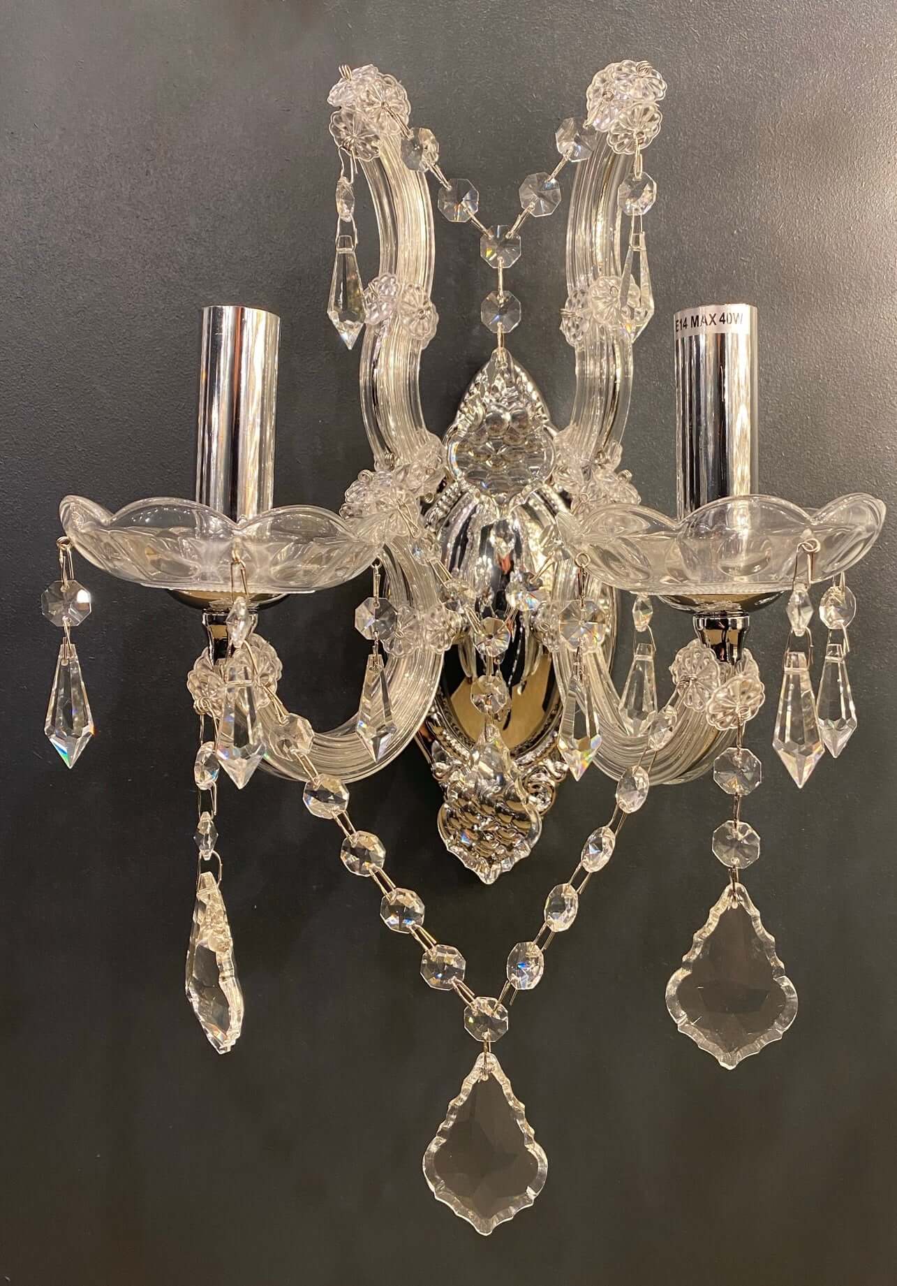 Elegant 2-light wall sconce with sparkling lead crystals and chrome finish, featuring intricate details and crystal glass arms.