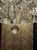 Close-up of a luxurious chandelier featuring sparkling crystal beads and a large crystal pendant.
