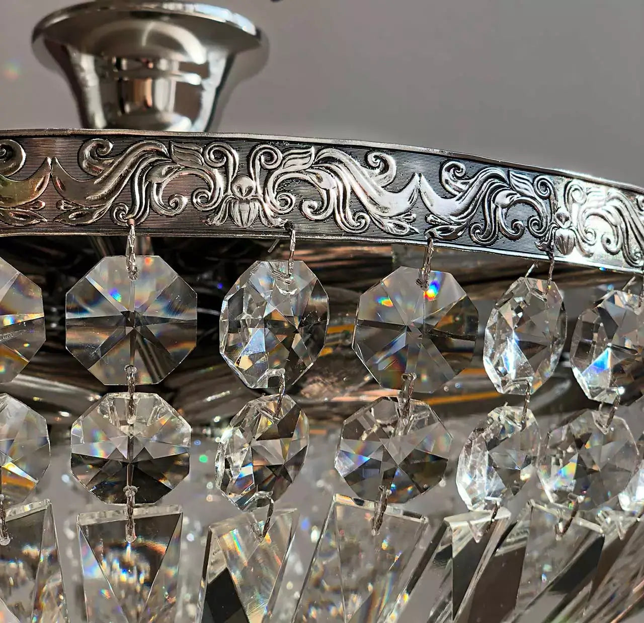 Close-up of Kristall Deckenleuchte Schönbrunn in antique silver with crystal accents, featuring intricate metal detailing.