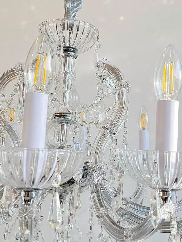 Close-up of Kristall Kronleuchter SERENADE chandelier with silver arms and crystal glass detailing.