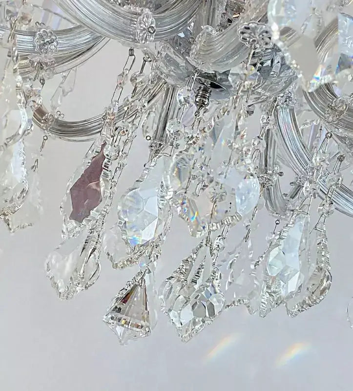 Close-up of Kristall Kronleuchter SERENADE chandelier with crystal glass arms and silver accents.