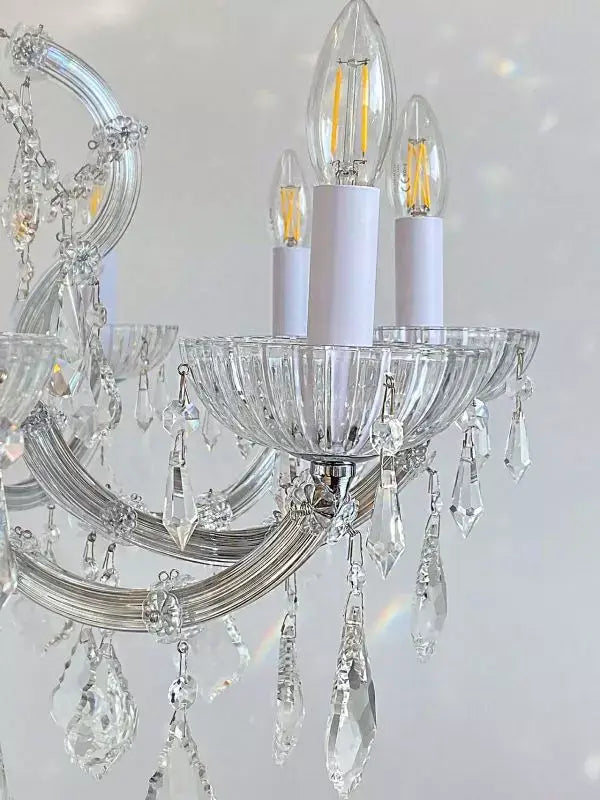 Close-up of a Maria Theresia SERENADE chandelier arm with crystal glass, featuring LED bulbs and detailed crystal decorations.