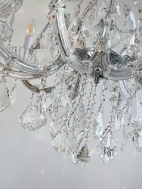 Luxurious Kristall Kronleuchter SERENADE chandelier with crystal glass arms and decorative crystals, silver finish, close-up detail.