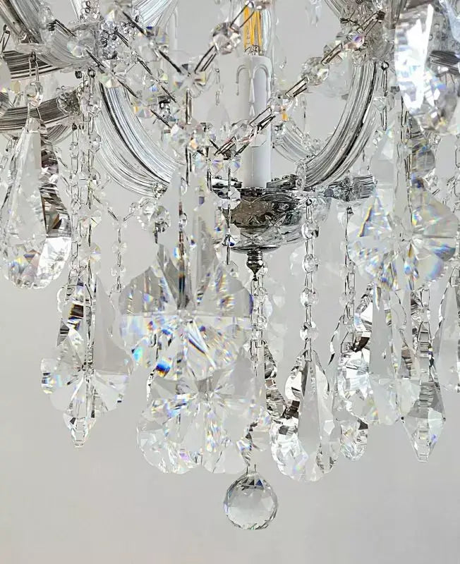 Close-up of the exclusive Beethoven crystal chandelier featuring silver-finished arms and hanging crystal glass decorations.
