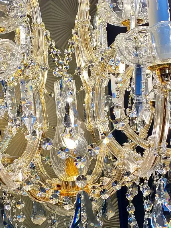 Close-up of the luxurious Michelangelo crystal chandelier featuring 24kt gold elements and crystal glass arms.