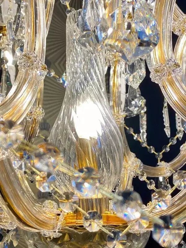 Close-up of gold and crystal arms on Michelangelo chandelier with embedded LED light, showcasing intricate crystal glass detailing.