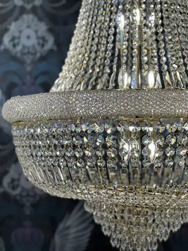 Elegant gold-colored crystal chandelier with intricate basket design and dazzling cut crystals, perfect for luxurious interiors.