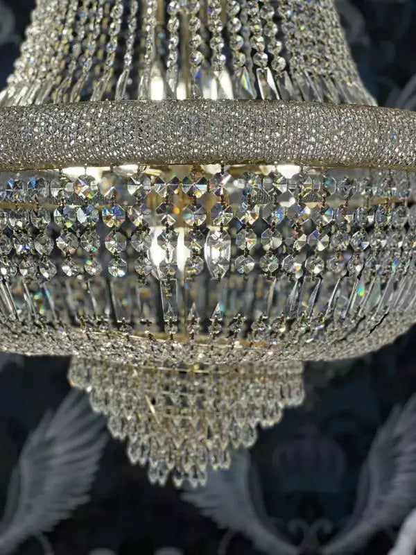 Gold-colored crystal chandelier with sparkling prisms, 80cm diameter, ideal for elegant interiors, dimmable lighting feature.