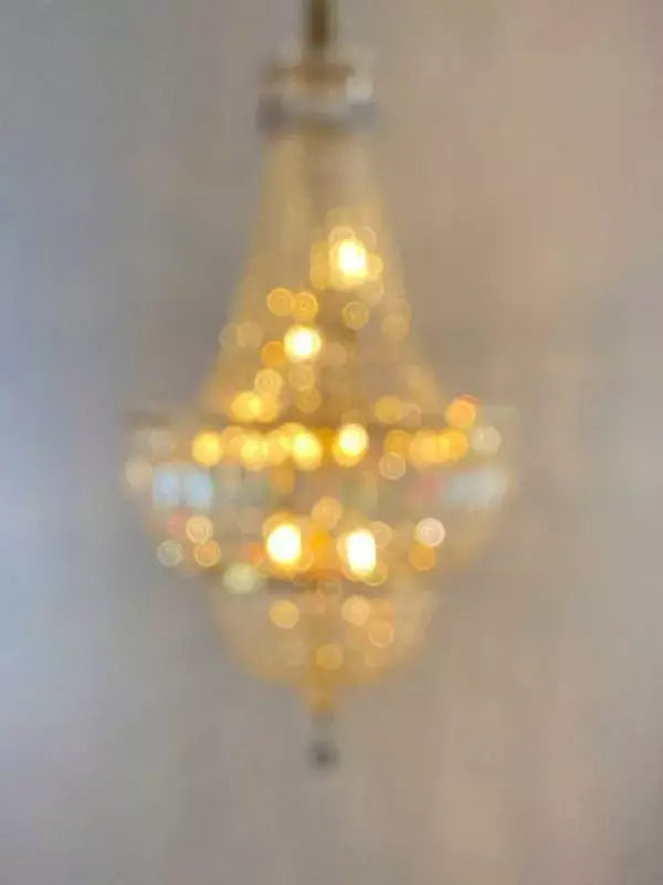 Elegant crystal chandelier with 24kt gold finish, featuring dimmable LED lights. Perfect for adding a luxurious touch to any room.