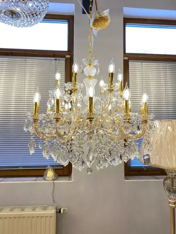 Kristall Kronleuchter Gold Ø77cm mit 18 Leuchten, funkelndes Bleikristall und Glasarme in einem eleganten Wohnraum.