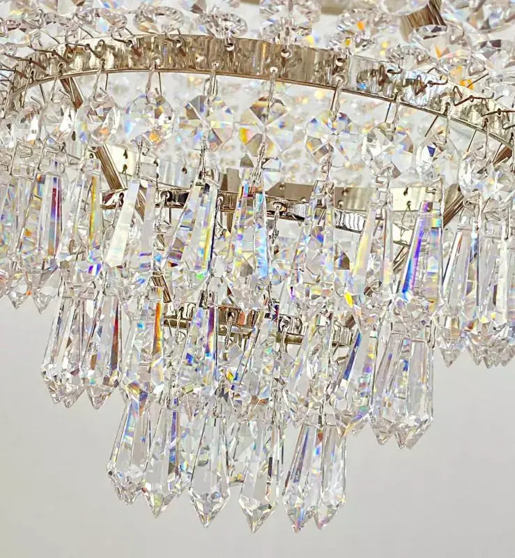 Close-up of Kristall Korblüster PLAZA chandelier with shimmering cut crystal drops and silver chrome finish.
