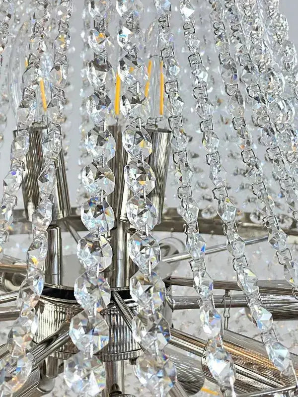 Close-up of a silver chandelier with cut crystal accents highlighting its elegant, shimmering design.
