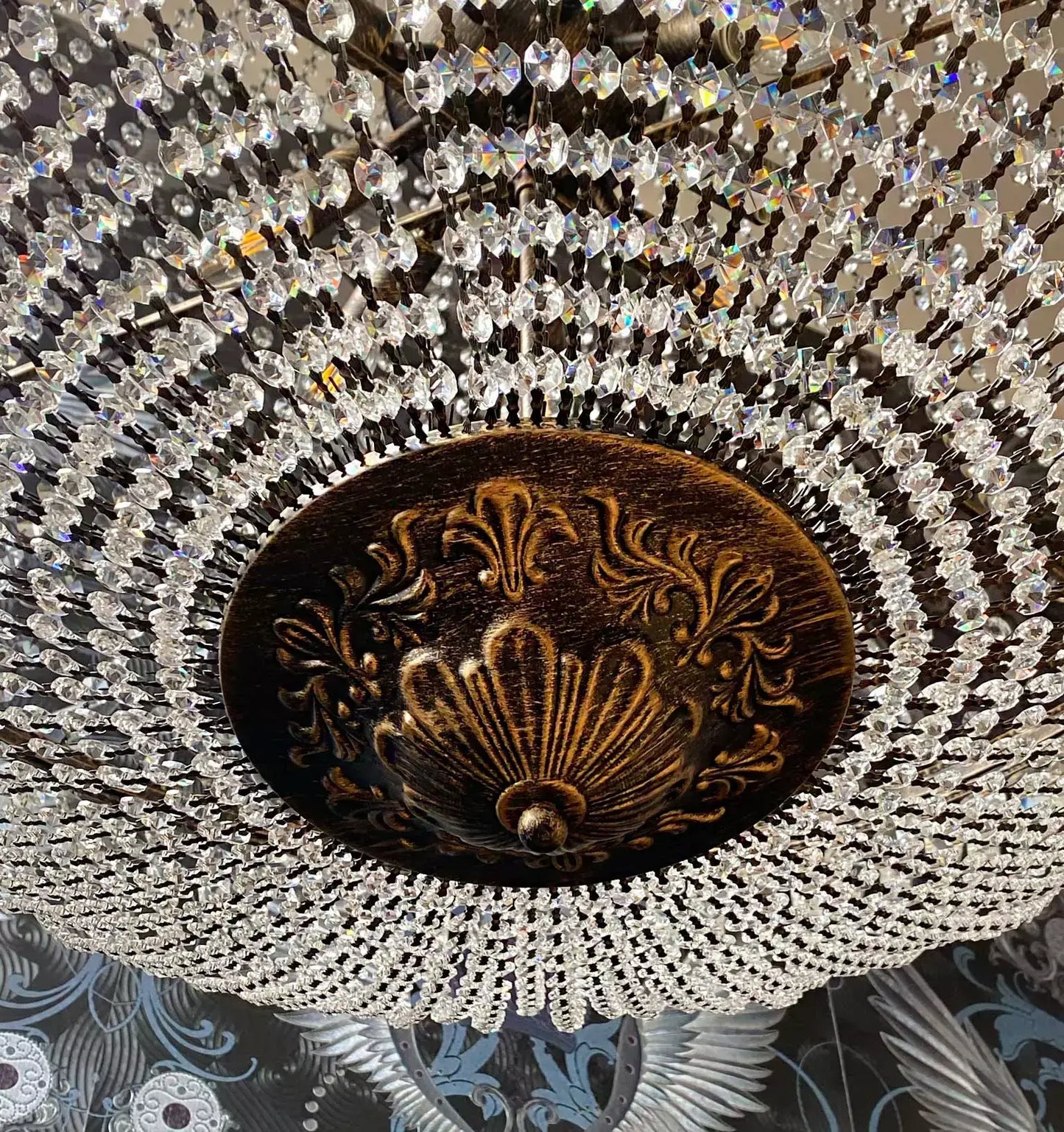 Close-up of the Kristall Korblüster Florence Antik with sparkling crystals and ornate design, 100cm in diameter, viewed from below.