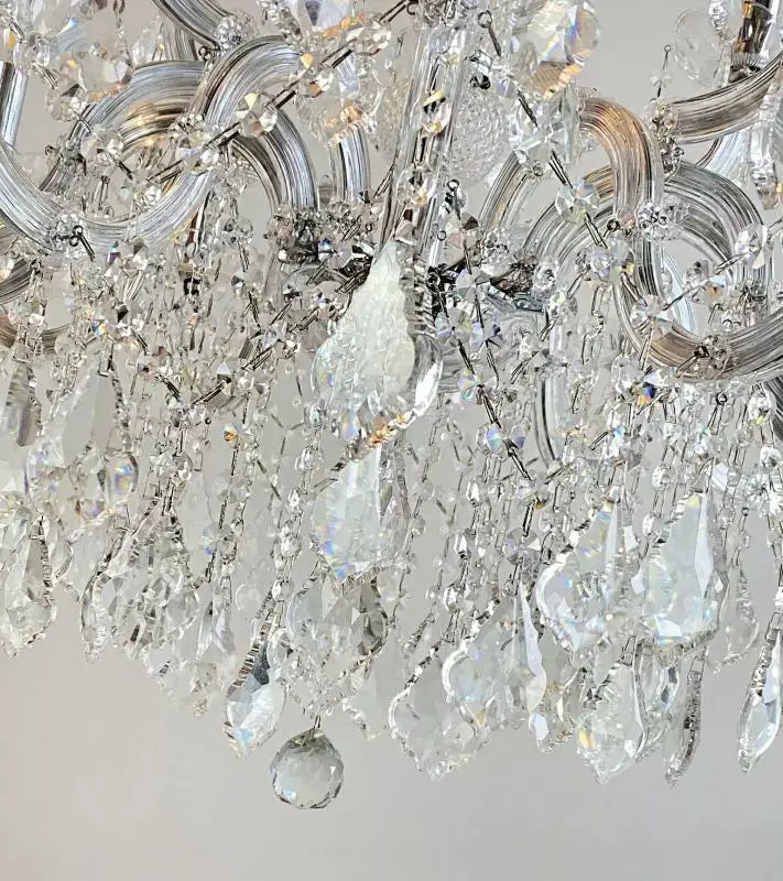 Close-up of a sparkling crystal chandelier with intricate glass arms and metal detailing.