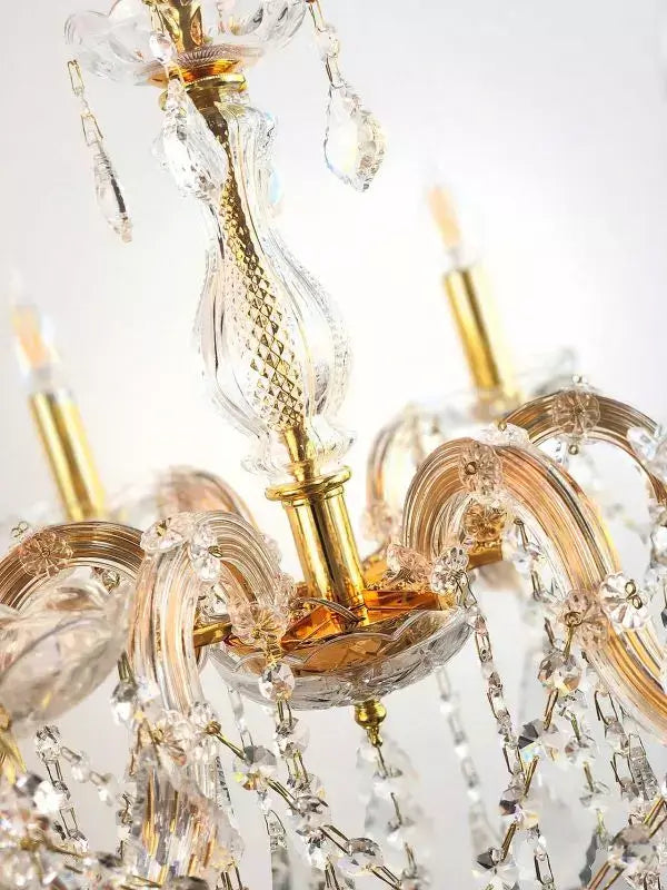 Elegant gold crystal chandelier with ornate arms and crystal details, featuring six lights for luxurious home decor.