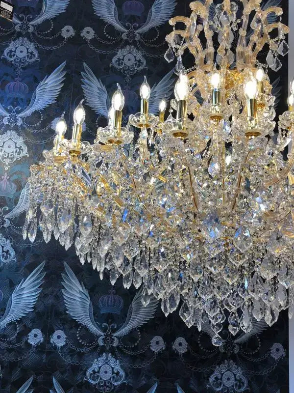 Gold Maria Theresia chandelier with crystal arms and 42 lights, shown in lavish setting, highlighting intricate design and brilliance.