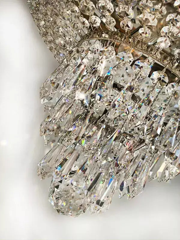 Close-up of a crystal chandelier with intricate silver detailing, showcasing sparkling cut crystals in a luxurious design.