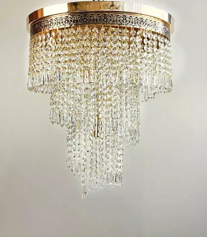 Luxurious gold crystal chandelier with French antique finish, featuring cascading crystal prisms, ideal for elegant interior settings.