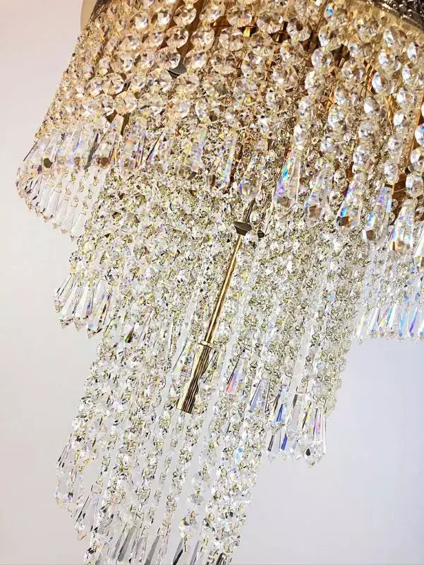 Close-up of the Bleikristall Twister chandelier with gold finish, featuring cut crystal strands, enhancing room elegance.