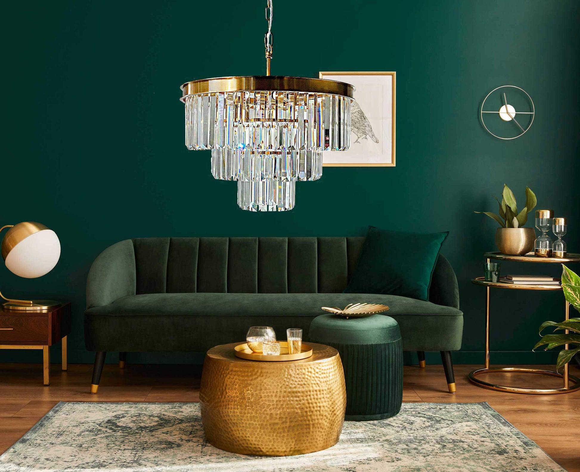 Elegant bronze and crystal pendant light in stylish green living room with modern décor and furniture.